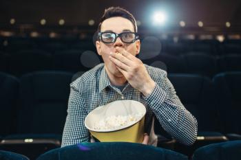 Teenager with popcorn fascinated watching the film in cinema. Showtime, entertainment industry