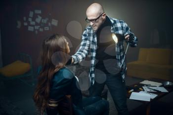 Maniac kidnapper shines a flashlight in the face of his victim. Kidnapping is a serious crime, crazy male psycho, kidnap horror, violence
