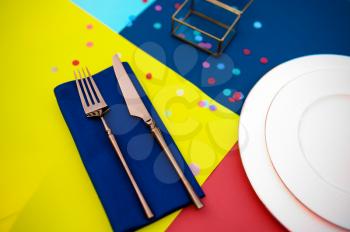Table setting, silverware and plate closeup, top view, nobody. Banquet decoration, colorful tablecloth and napkins, tableware outdoors