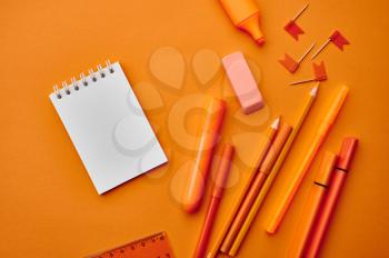 Office stationery supplies,macro view, orange background. School or education accessories, writing and drawing tools
