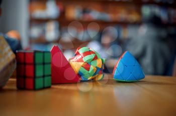 Different colorful puzzle cubes on the table, nobody. Toy for brain and logical mind training, creative game, solving of complex problems