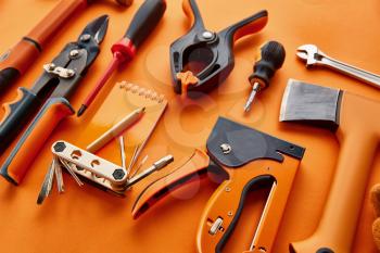 Professional workshop instrument, red background, nobody. Carpenter tools, builder equipment, screwdriver and piles, hammer and axe