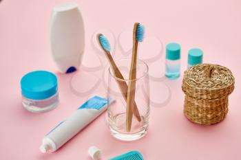 Oral care products, two toothbrush and toothpaste, macro view, pink background, nobody. Morning healthcare procedures concept