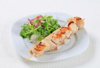 Chicken skewer with mixed salad greens