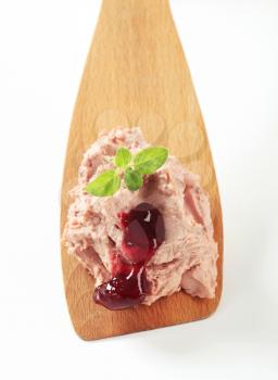 Liver pate and cranberry sauce on a wooden spoon 