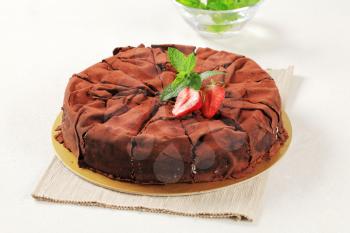 Delicious cake covered with chocolate sheets