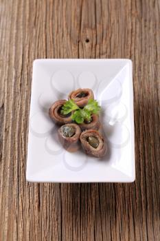 Rolled up anchovy fillets filled with capers