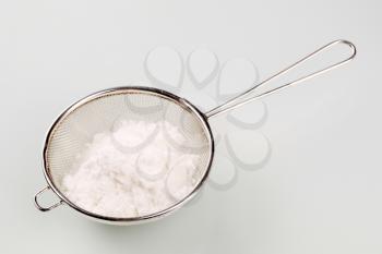 Heap of powdered sugar in a sieve