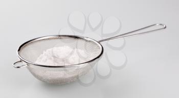 Heap of powdered sugar in a sieve