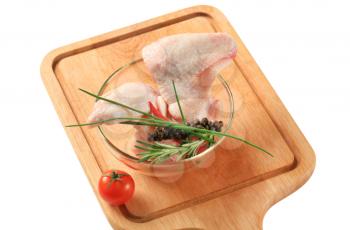 Raw chicken wings and other ingredients on cutting board