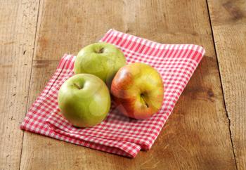 Three fresh apples on a rustic table
