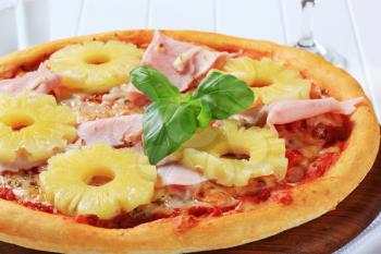 Pizza with pieces of ham and pineapple