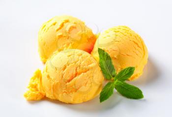Scoops of yellow ice cream on a plate