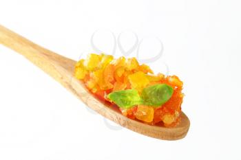 Candied citrus peel on wooden spoon