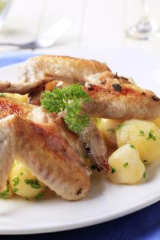 Roasted chicken wings and potatoes - closeup