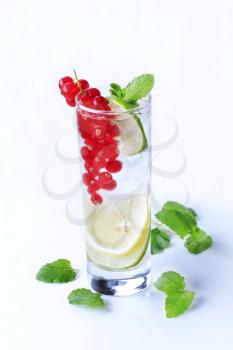 Glass of iced lemonade garnished with red currant