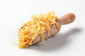 Grated cheese on a wooden scoop