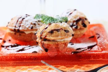 Walnut shaped cookies with creamy filling, drizzled with chocolate syrup 