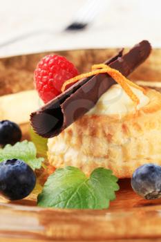 Cream filled vol-au-vent garnished with chocolate curl and fruit