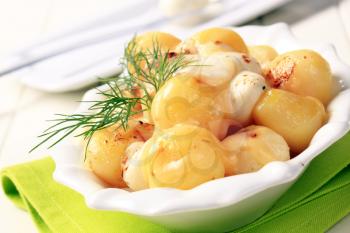 Bowl of potatoes topped with melted cheese and butter