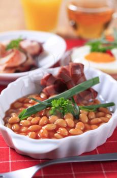 English breakfast of baked beans, sausages, fried egg and bacon