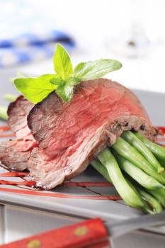 Slices of roast beef with string beans