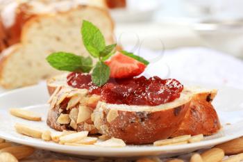 Slice of sweet bread with jam and almonds