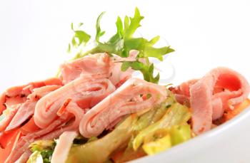 Green salad topped with sliced ham