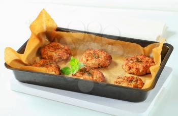 Vegetable patties on baking parchment paper in baking pan