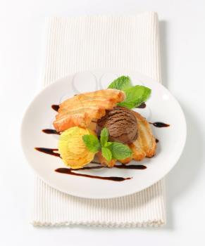 Two scoops of ice cream with puff pastry biscuits