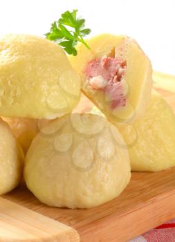 Meat stuffed potato dumplings on cutting board