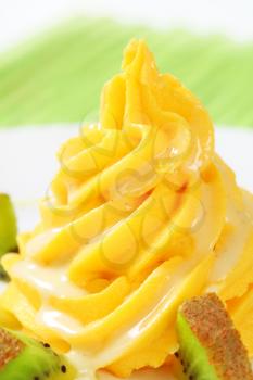 Swirl of yellow cream with fresh kiwi