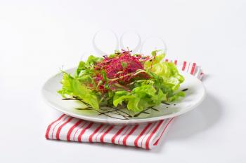 Mixed green salad garnished with balsamic vinegar