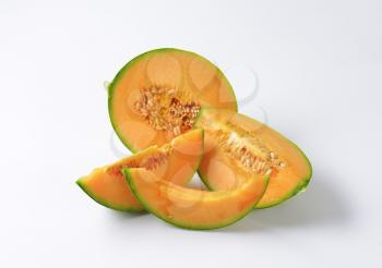 Slices of cantaloupe melon on white background