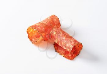 Black pepper-coated salami speckled with pieces of Comte cheese - thinly sliced