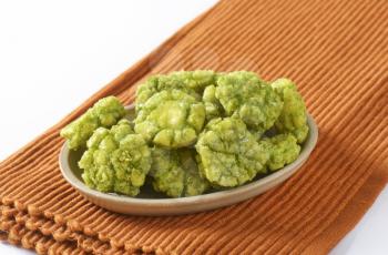 bowl of wasabi crackers on brown place mat