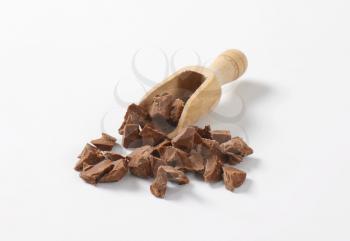 milk chocolate pieces on wooden scoop