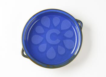 Empty round ceramic baking dish with two handles