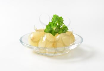 Small pickled onions on glass plate