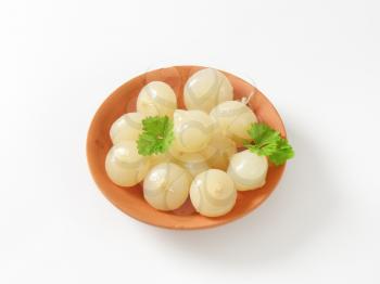 Small pickled onions on terracotta plate