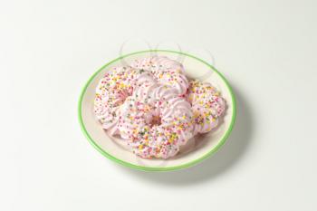 Wreath-shaped meringue cookies decorated with colorful sprinkles