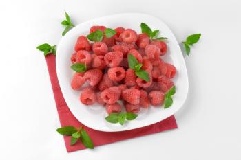 plate of fresh raspberries on red paper napkin