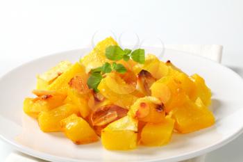 Portion of roasted pumpkin and garlic on white plate