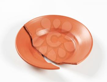 two pieces of a broken terracotta plate