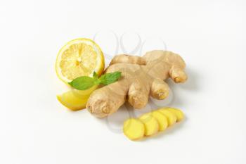 sliced ginger with lemon on off-white background with shadows