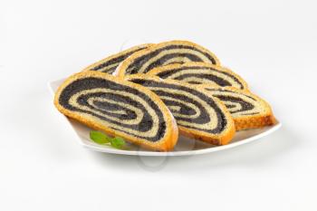 slices of poppy seed roll on white plate