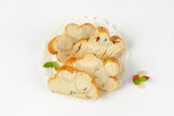 Slices of Christmas sweet braided bread with almonds and raisins