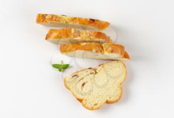 Slices of Christmas sweet braided bread with almonds and raisins