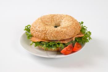 sesame bagel sandwich with smoked salmon on white plate