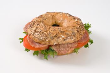 bagel sandwich with salami on white background